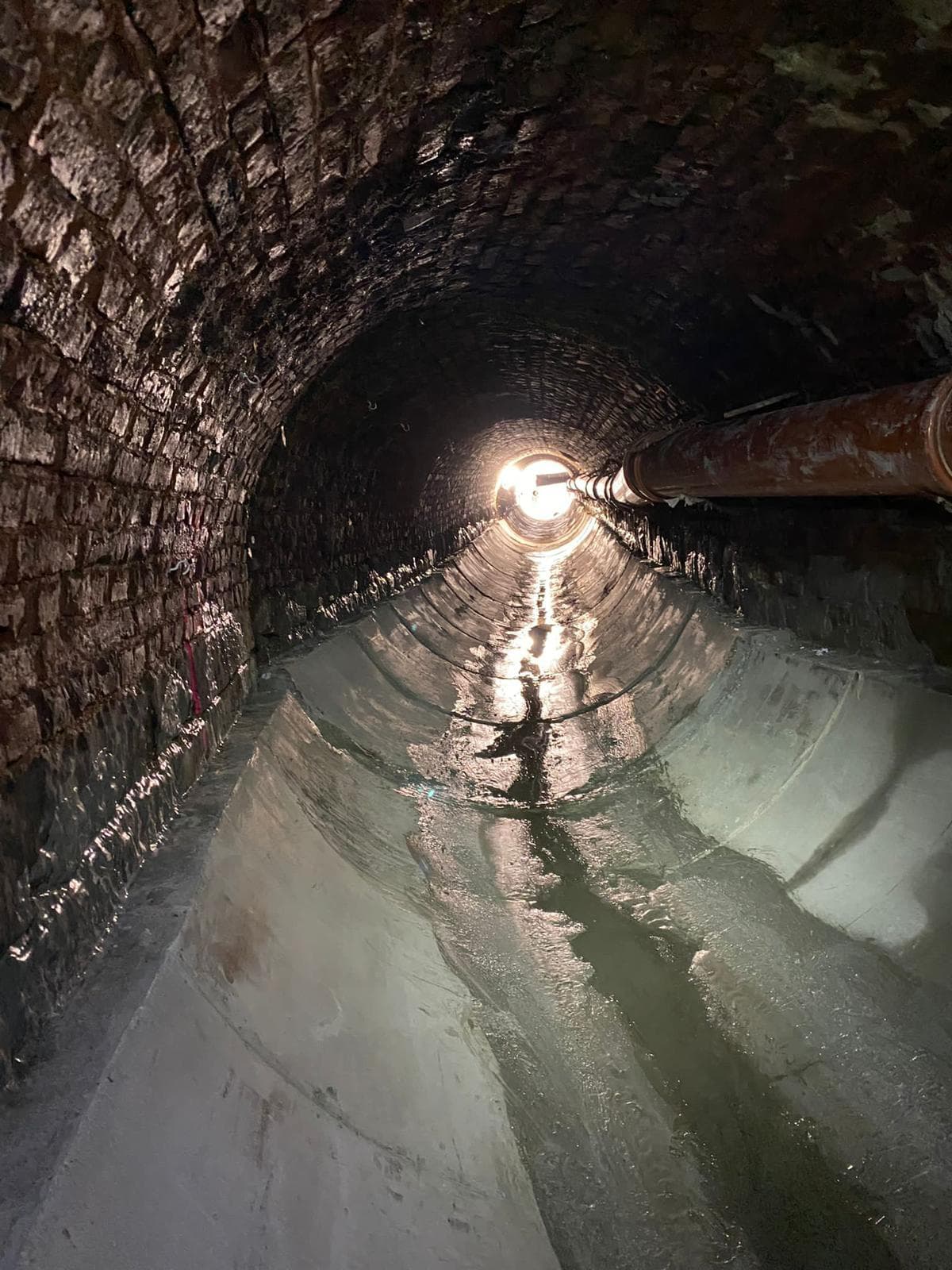 Teilfertige Sohlschale nach Ausbau der Schalkörper. Das Licht im hinteren Bereich des Kanals lässt bereits deutlich die gewünschte Kreisform erkennen. (SMG)
